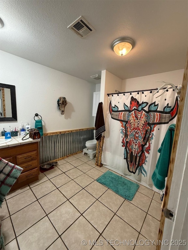 bathroom with vanity, toilet, tile patterned floors, a shower with curtain, and visible vents