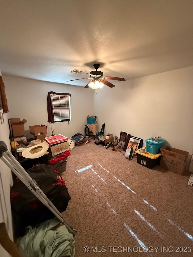 interior space featuring a ceiling fan, carpet flooring, and visible vents