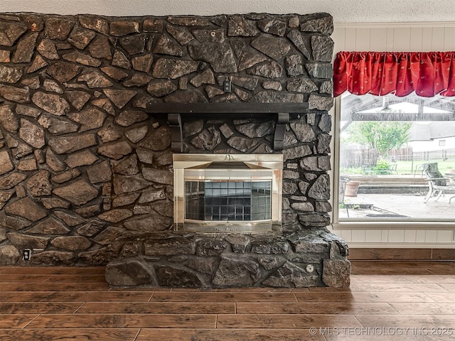 room details featuring a stone fireplace and wood finished floors