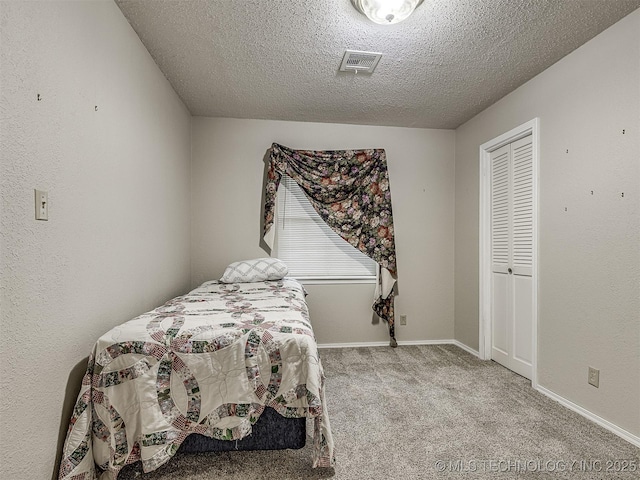 carpeted bedroom with a textured ceiling and visible vents
