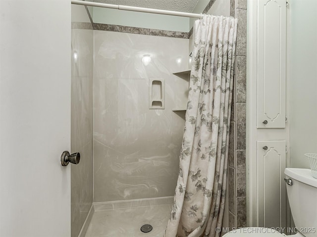 bathroom featuring toilet and a stall shower