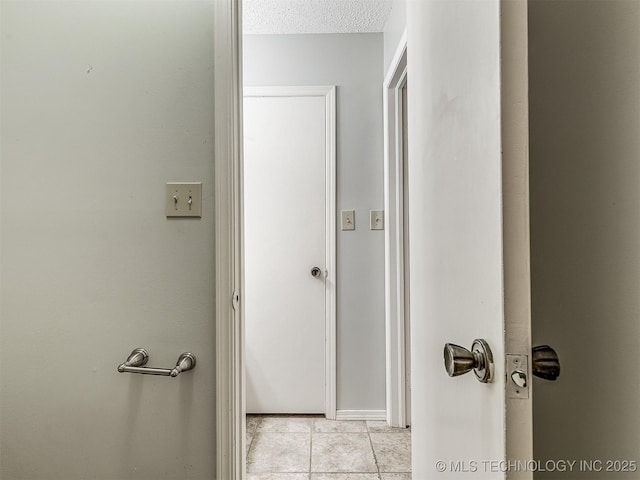 bathroom featuring a textured ceiling and tile patterned floors