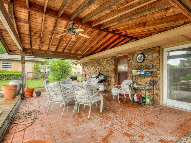 view of patio with a ceiling fan, fence, and outdoor dining space