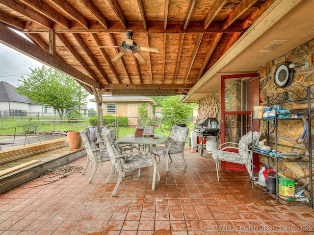 view of patio with area for grilling, fence, a ceiling fan, and outdoor dining area