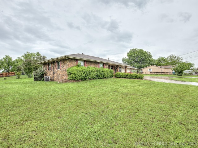 single story home with driveway, a front yard, and stone siding