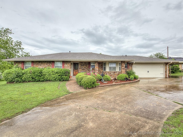 ranch-style home with a garage, stone siding, a front yard, and concrete driveway