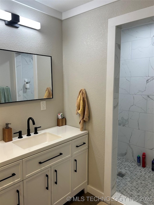 1705 Tower Dr, Ardmore, OK 73401 - bathroom with a tile shower, vanity, and a textured wall