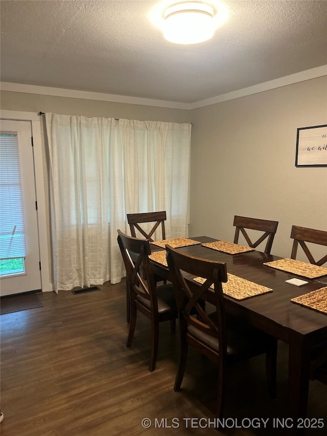 1705 Tower Dr, Ardmore, OK 73401 - dining area with dark wood-style flooring, crown molding, and a textured ceiling