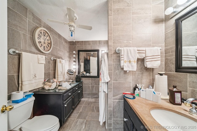 25805 S Clayton Ave, Claremore, OK 74019 - bathroom with ceiling fan, vanity, toilet, a textured ceiling, and tile walls