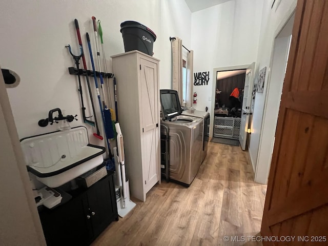 washroom featuring cabinet space, separate washer and dryer, and light wood-style floors