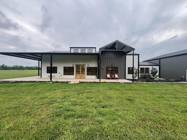 rear view of property with french doors, a patio, board and batten siding, and a yard