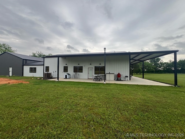 rear view of house featuring board and batten siding, a patio area, central air condition unit, and a yard