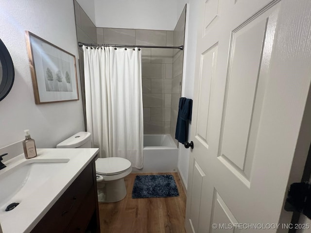 bathroom featuring vanity, wood finished floors, toilet, and shower / bath combo with shower curtain
