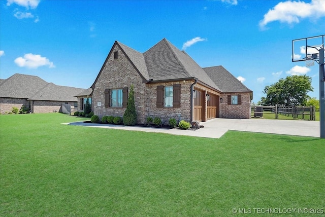 view of front of house with brick siding, an attached garage, driveway, and a front lawn