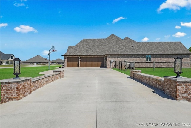 view of side of home with fence, an attached garage, a shingled roof, concrete driveway, and a lawn