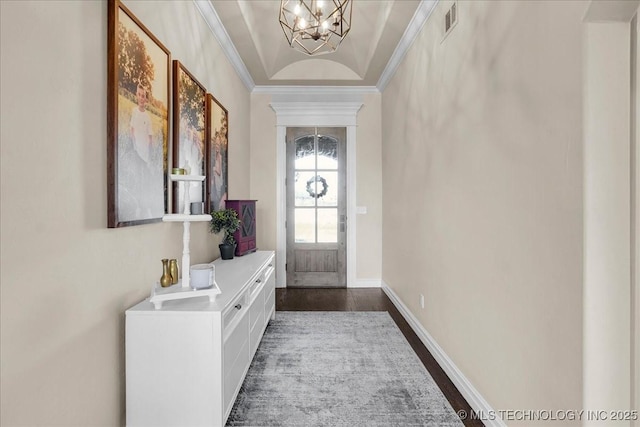 foyer featuring visible vents, dark wood finished floors, baseboards, a notable chandelier, and ornamental molding