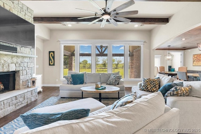 living room with ceiling fan, a fireplace, wood finished floors, baseboards, and beamed ceiling