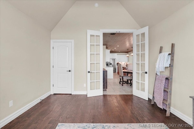 interior space featuring baseboards, french doors, high vaulted ceiling, and wood finished floors