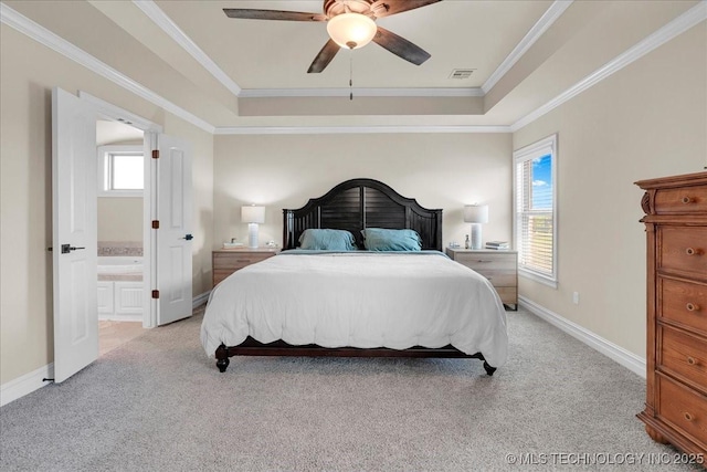 bedroom featuring a raised ceiling, light carpet, and multiple windows