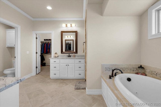bathroom with crown molding, vanity, toilet, a tub with jets, and tile patterned floors