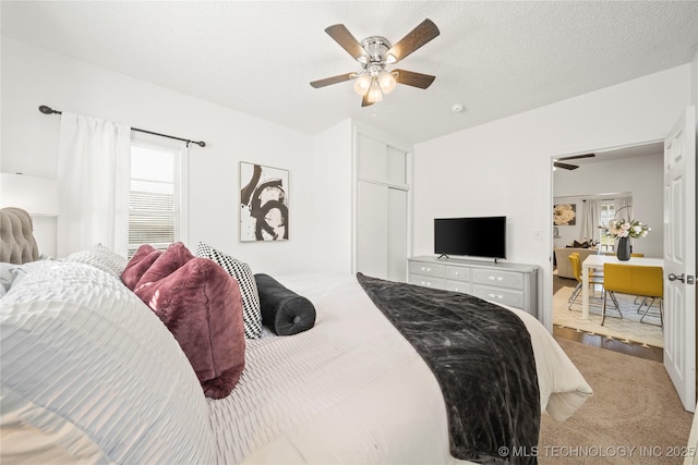 bedroom with multiple windows, a ceiling fan, and carpet flooring