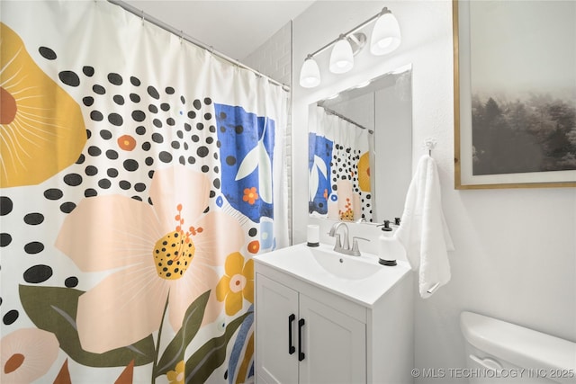 bathroom featuring vanity, curtained shower, and toilet