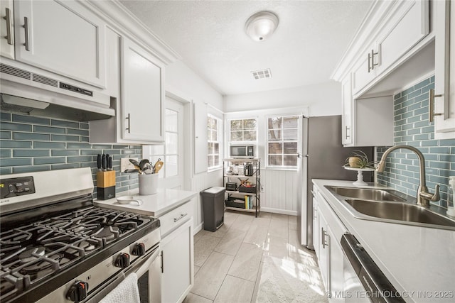 kitchen featuring visible vents, light countertops, white cabinetry, a sink, and appliances with stainless steel finishes