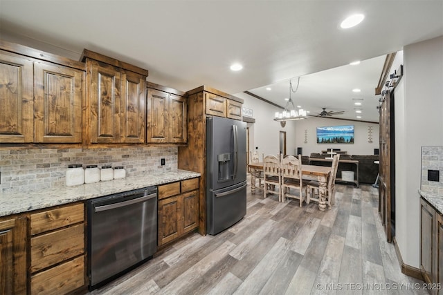 kitchen with light stone countertops, light wood-style floors, stainless steel appliances, recessed lighting, and tasteful backsplash