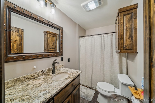 bathroom featuring vanity, toilet, wood finished floors, and visible vents