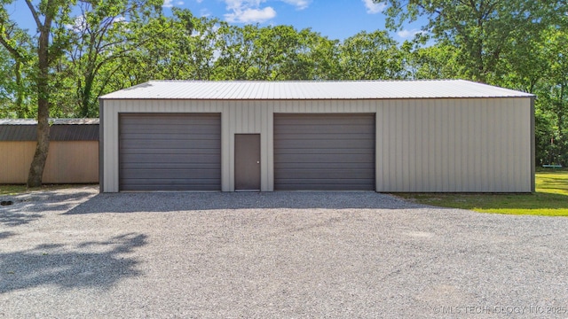 detached garage with gravel driveway