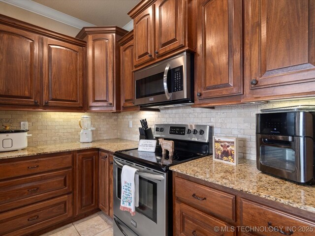 5406 Ashbrook Dr, Bartlesville, OK 74006 - kitchen with appliances with stainless steel finishes, decorative backsplash, light stone countertops, and ornamental molding