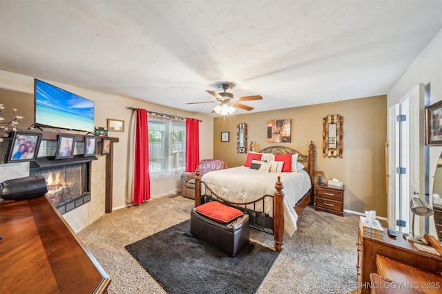 bedroom with carpet floors, a ceiling fan, baseboards, and a fireplace