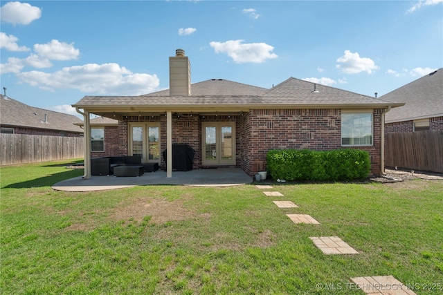 back of property with french doors, a fenced backyard, a patio area, and brick siding