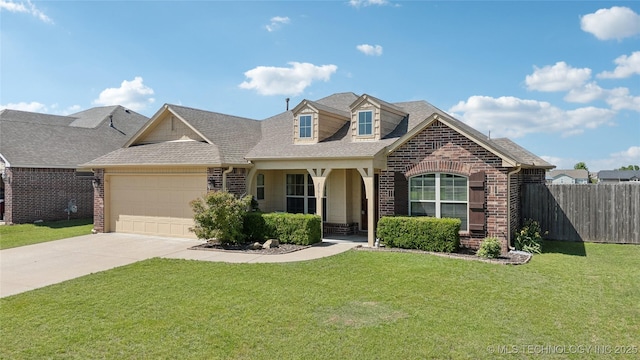 view of front of house featuring fence, an attached garage, a front yard, and brick siding