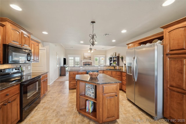 kitchen featuring decorative backsplash, a peninsula, recessed lighting, a sink, and black appliances