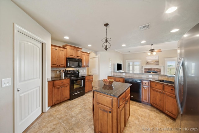kitchen with a kitchen island, visible vents, black appliances, and tasteful backsplash