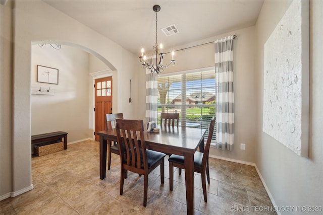 dining area featuring arched walkways, baseboards, a chandelier, and visible vents