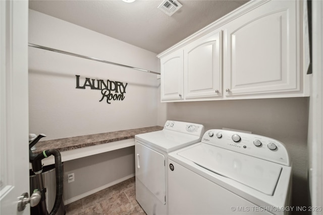 washroom featuring baseboards, visible vents, cabinet space, and washing machine and clothes dryer