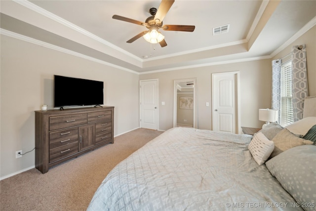 bedroom featuring crown molding, light carpet, a tray ceiling, and visible vents