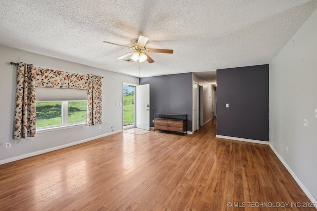 35617 W 261st St S, Bristow, OK 74010 - unfurnished living room featuring a textured ceiling, ceiling fan, wood finished floors, and baseboards