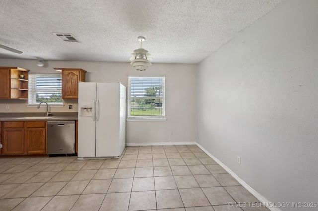 35617 W 261st St S, Bristow, OK 74010 - kitchen with white fridge with ice dispenser, dishwasher, a sink, a textured ceiling, and brown cabinetry