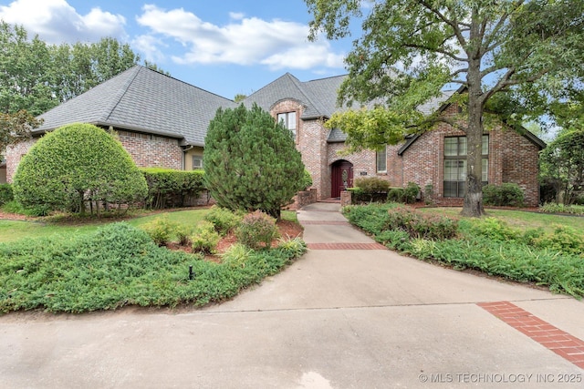 view of front of house featuring brick siding and a high end roof