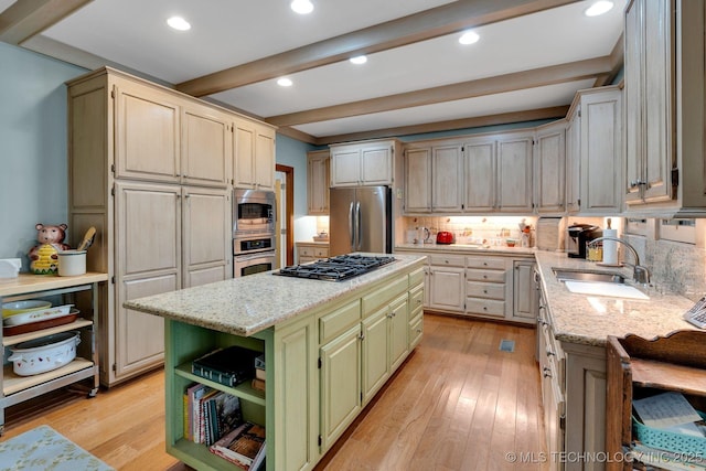 kitchen featuring beam ceiling, green cabinetry, tasteful backsplash, a sink, and stainless steel appliances