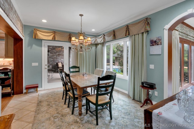 dining space featuring crown molding, arched walkways, plenty of natural light, and light tile patterned flooring