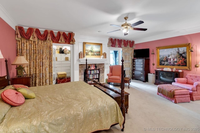 bedroom with carpet floors, a ceiling fan, crown molding, and a fireplace