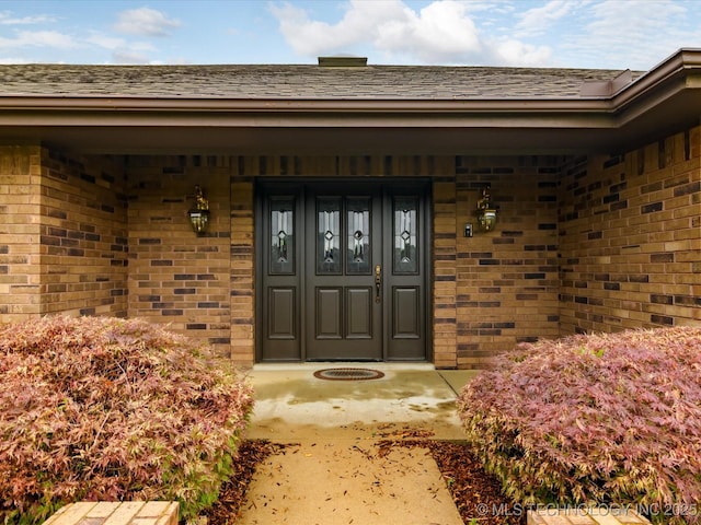 view of exterior entry featuring brick siding