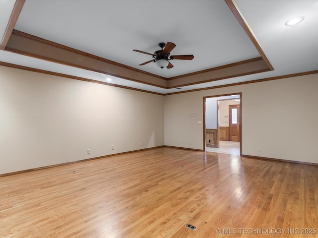 unfurnished room with crown molding, a raised ceiling, ceiling fan, and light wood-style floors
