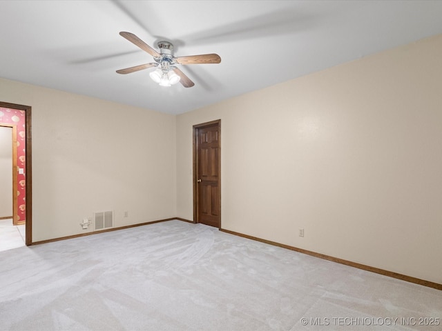 spare room featuring baseboards, ceiling fan, light colored carpet, and visible vents
