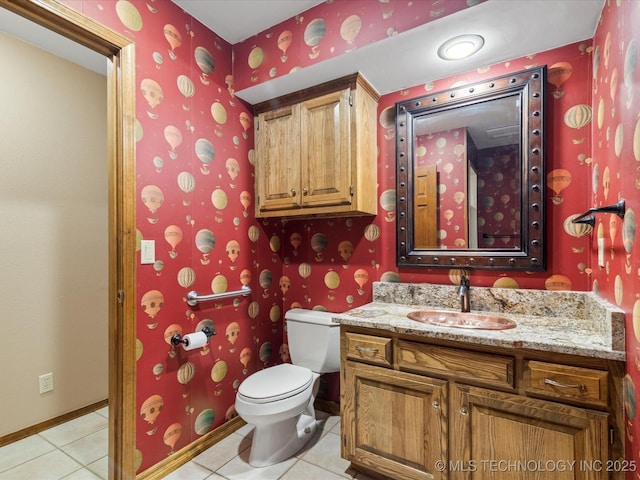 half bathroom with tile patterned flooring, wallpapered walls, toilet, and vanity