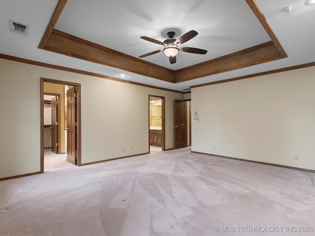 empty room featuring crown molding, a tray ceiling, visible vents, and ceiling fan